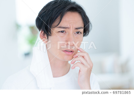 嘗試一個微笑的年輕人早晨戴上面具 69781865