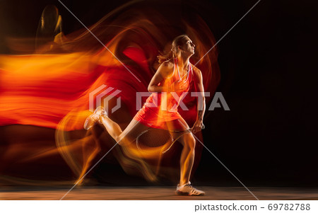 Professional female tennis player isolated on black studio background in mixed light 69782788