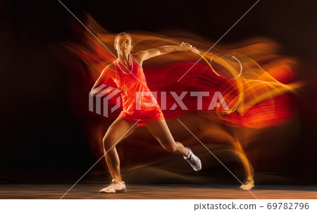 Professional female tennis player isolated on black studio background in mixed light 69782796