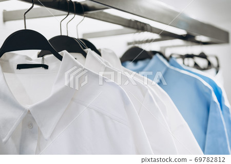 White and blue shirts on hangers in fashion store. Selective focus 69782812