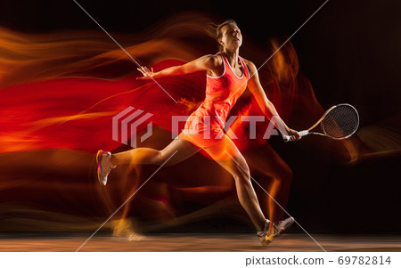 Professional female tennis player isolated on black studio background in mixed light 69782814
