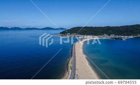 A straight road leading to an island sandwiched between the sea seen from the sky A straight road leading to an island sandwiched between the sea seen from the sky 69784555