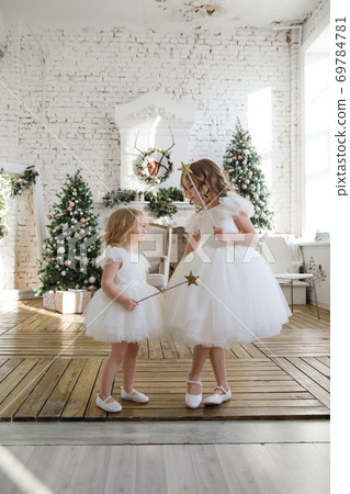 girls on background of Christmas trees in loft. girls on background of Christmas trees in loft. 69784781