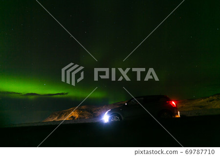 Northern lights in the night sky of iceland. Soft focus. Magical green glow. Northern lights in the night sky of iceland. Soft focus. Magical green glow. 69787710