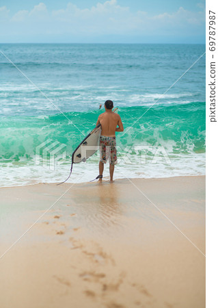 Surfer. Surfing Man With Surfboard Walking On Sandy tropical Beach. Healthy Lifestyle, water activities, Water Sport. Beautiful Ocean. 69787987