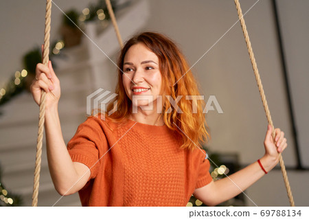 A beautiful redhead girl is swinging in her room on Christmas night A beautiful redhead girl is swinging in her room on Christmas night 69788134