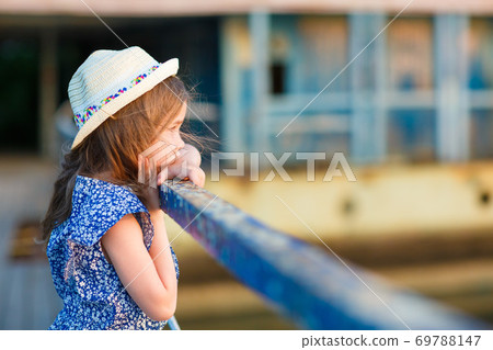kid girl in blue clothes standing old bridge 69788147