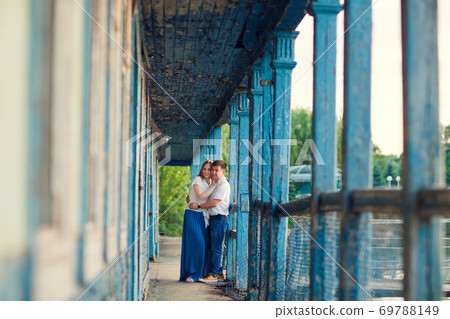 couple standing on porch of old ruined house. 69788149