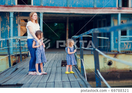 mom and kids in blue clothes standing old bridge 69788321