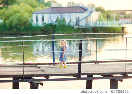 kid girl in blue clothes standing old bridge 69788391
