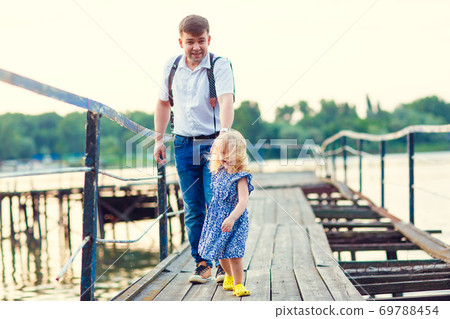 kid girl and dad in blue clothes going old bridge 69788454