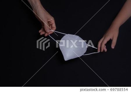 Child and woman's hand with protective mask 69788554