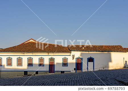 Facade of old house in colonial style architecture with blue windows and door 69788703
