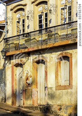 Facade of old house in colonial architecture worn by time 69788704