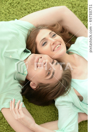 Happy young couple in love lying on floor at home Happy young couple in love lying on floor at home 69788751