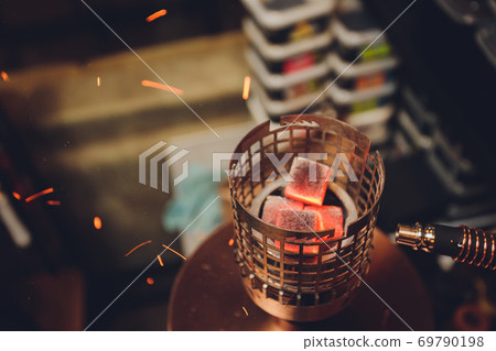 Coals for hookah close-up. Burning coals on the hookah bowl. Coals for hookah close-up. Burning coals on the hookah bowl. 69790198