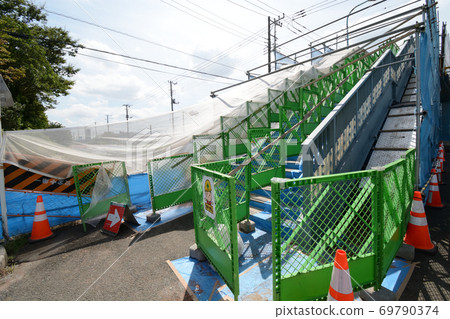 Crossing pedestrian bridge under repainting repair work 69790374