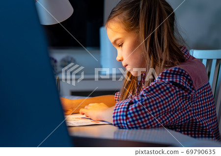 at night schoolgirl do homework, studying at home. 69790635