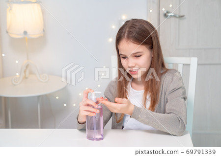 girl uses disinfectant to clean their hands. girl uses disinfectant to clean their hands. 69791339