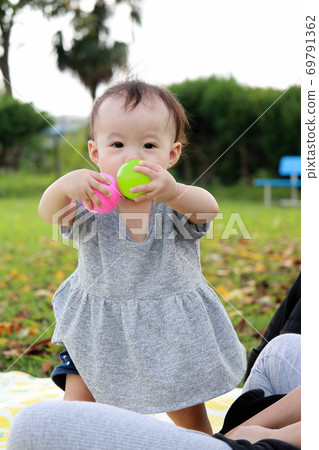1 year old girl playing in the autumn park 1 year old girl playing in the autumn park 69791362