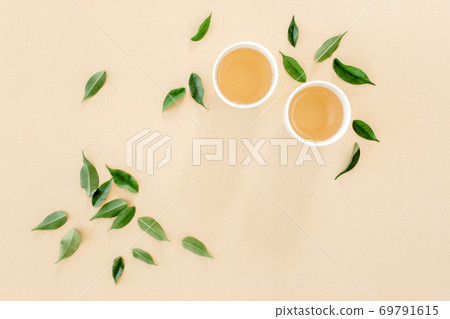 Cup of fresh green tea with tea leaves. Flat lay, top view. Tea concept 69791615
