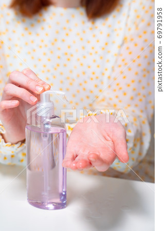 hygiene female uses disinfectant to clean  hands. 69791958