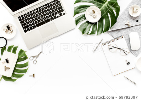Home office workspace mockup with laptop, tropical leaves Monstera, clipboard, notebook and accessories on white background. Flat lay, top view 69792397