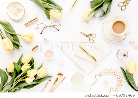 Female workspace with yellow tulip flowers, women's fashion golden accessories, diary, glasses on white background. Flat lay. Top view background. 69792469