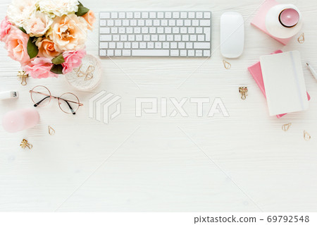 Flat lay women's office desk. Female workspace with computer, pink roses flowers, accessories, golden diary, glasses on white background. Top view Flat lay women's office desk. Female workspace with computer, pink roses flowers, accessories, golden diary, glasses on white background. Top view 69792548