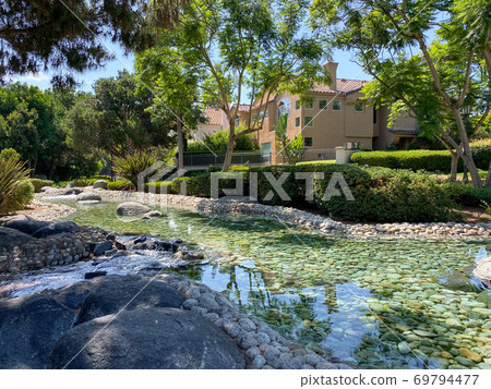 Public Park with green garden and landscape design with water pond and water stream Public Park with green garden and landscape design with water pond and water stream 69794477