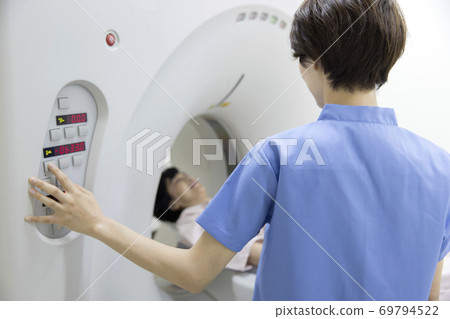 接受CT檢查的中年婦女和放射科醫生 接受CT檢查的中年婦女和放射科醫生 69794522