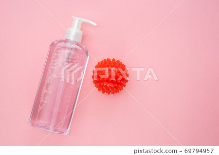 bottle of antiseptic and model COVID-19 on pink. bottle of antiseptic and model COVID-19 on pink. 69794957