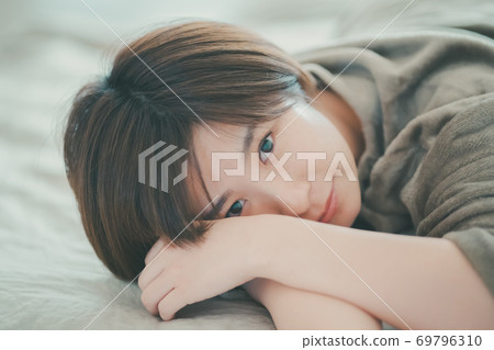 Woman in pajamas lying on the bed Woman in pajamas lying on the bed 69796310