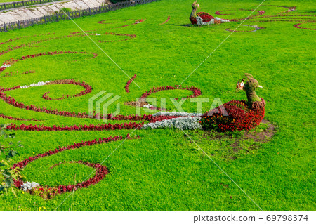 Floral figures of birds on a lawn in a garden 69798374