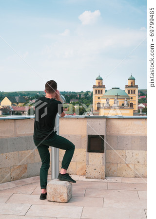 Tourist young man watching the city Eger through a telescope Tourist young man watching the city Eger through a telescope 69799485
