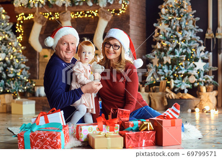 Grandparents and little girl in the house at Christmas. Grandparents and little girl in the house at Christmas. 69799571