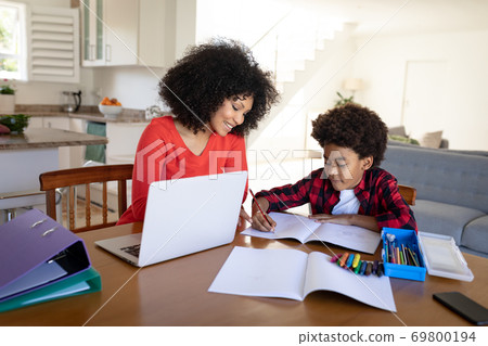 Mother helping son with homework at home 69800194
