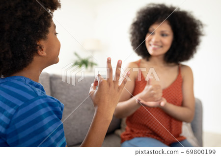 Mother and son communicating with each other in sign language 69800199