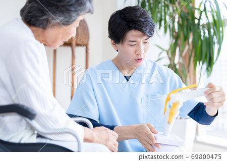 Medical doctor explaining using a knee joint model Medical doctor explaining using a knee joint model 69800475