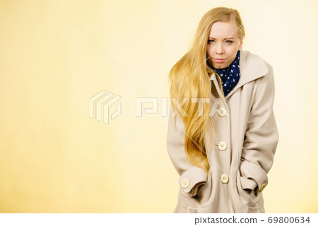 Woman wearing autumnal beige coat Woman wearing autumnal beige coat 69800634