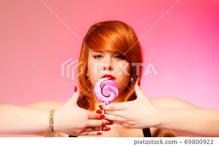 Woman with sweet candy lollipop in hand. 69800922