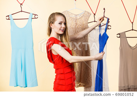 Woman in shop or wardrobe picking dress Woman in shop or wardrobe picking dress 69801052