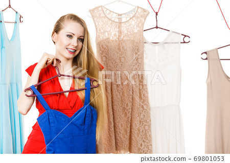 Woman in shop or wardrobe picking dress Woman in shop or wardrobe picking dress 69801053