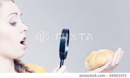 Shocked woman magnifying bun bread roll Shocked woman magnifying bun bread roll 69801055