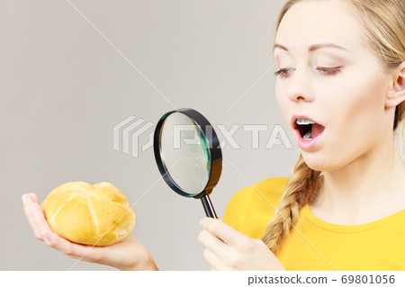 Shocked woman magnifying bun bread roll Shocked woman magnifying bun bread roll 69801056