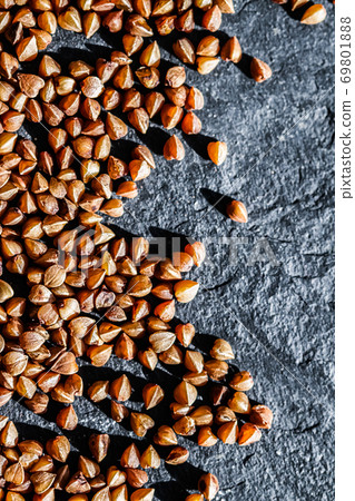 Buckwheat grain closeup, food texture and cook book background Buckwheat grain closeup, food texture and cook book background 69801888