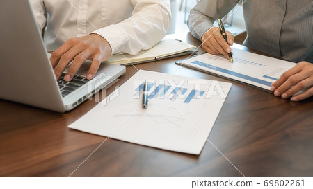 Business team brainstorming and discussing with financial data and report graph. Business team brainstorming and discussing with financial data and report graph. 69802261