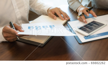 Business team brainstorming and discussing with financial data and report graph. Business team brainstorming and discussing with financial data and report graph. 69802262
