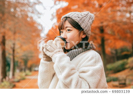 女人在冬季公園喝熱飲料 女人在冬季公園喝熱飲料 69803139