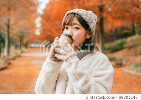 女人在冬季公園喝熱飲料 女人在冬季公園喝熱飲料 69803143